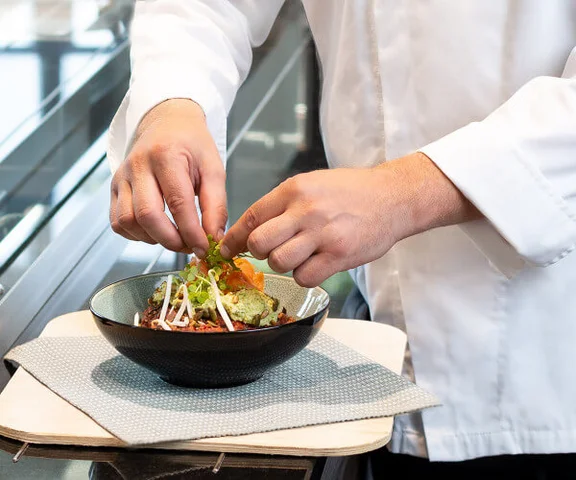 ein Koch richtet ein Tellergericht an