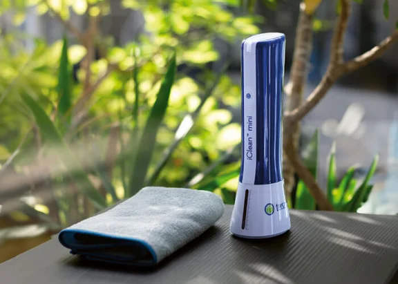Ein Bild von einem Mikrofasertuch und ein iClean mini Ozonengenerator auf einer dunklenoberfläche auf einer Terasse