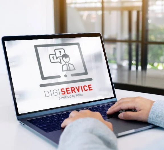 zwei Hände an einem Notebook und auf dem Bildschirm ist das Logo: Digi Service powered by Klüh zu sehen.
