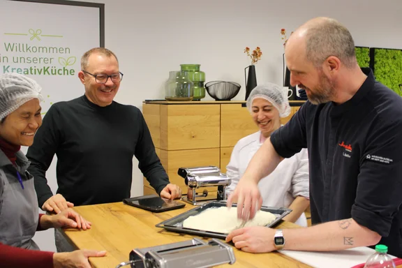 Vier Personen bereiten eine Speise vor