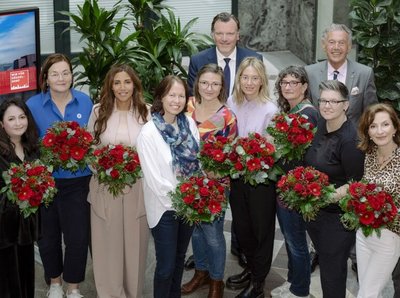 Ein Gruppenbild zur Spendeninitiative "Wir für Düsseldorf", dabei halten alle Frauen auf dem Bild rote Blumen Strauße in der Hand