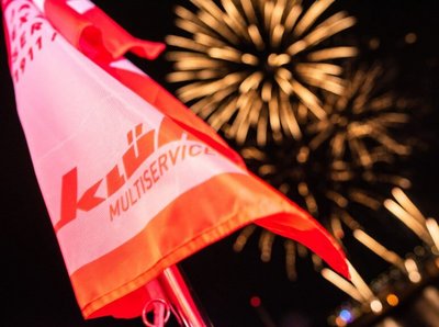 Klüh Multiservices Fahne und im Hintergrund ein Feuerwerk