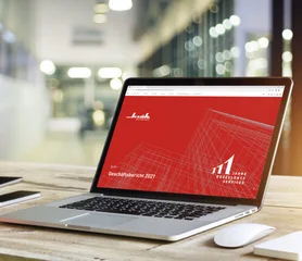 Ein Laptop auf dem der Klüh-Geschäftsbericht 2021 geöffnet ist