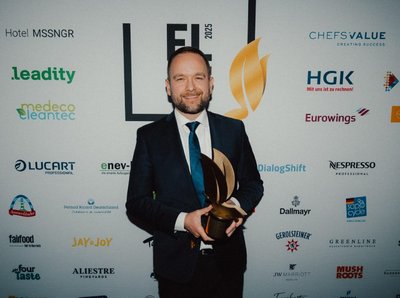 [Translate to Englisch:] Klüh Mitarbeiter Robin Krielke mit dem Green Monarch-Preis