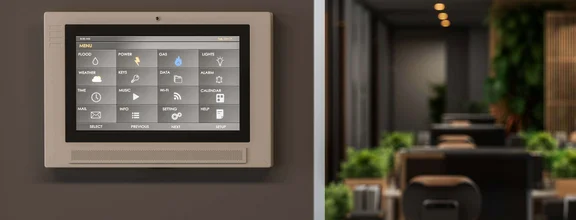 ein großer möbilierter Büroraum mit einem Smart-Tablet an der Wand zu Steuerung wie: Licht oder Alarmanlage