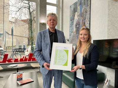 Herr Christian Frank und eine Frau präsentieren die GMS-Bescheinigung