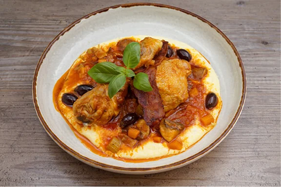Tellergericht Hähnchen „Cacciatore“ mit geschmorten Tomaten, Oliven und cremiger Polenta