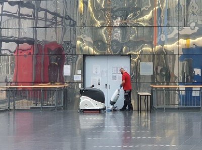 ein Mann reinigt ein Gebäude mit einem Staubsauger