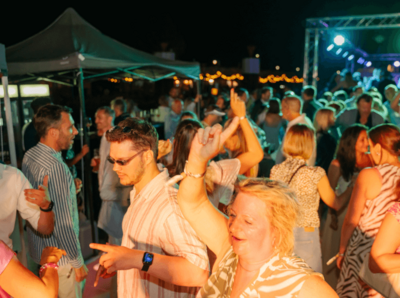 Gruppe von Menschen tanzend auf dem Schiffsdeck am Abend
