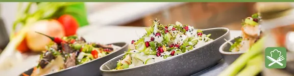 Das Bild zeigt frische und gesunde Lebensmittel und Salatkreationen, die schön auf Tellern angerichtet sind.