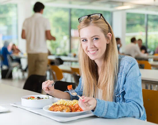 Collage aus drei Bildern mit einer lächelnden jungen Frau in der Mensa sitzend mit ihrem Essen auf einem Tablet, ein Mann im Krankenhausbett sitzend und lächelnd mit einem Essentablett vor sich und einer Seniorin sitzend und lächelnd mit Tellergerichten vor sich