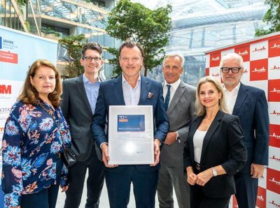 Ein Gruppenbild von 5 Personen in Business Outfits, die eine Auszeihnung in den Händen halten