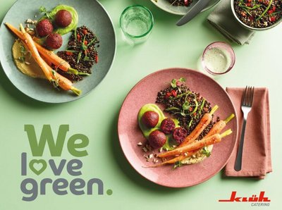Aktionsbild von "We love green." mit zwei Tellergerichten auf einem gedeckten grünen Tisch