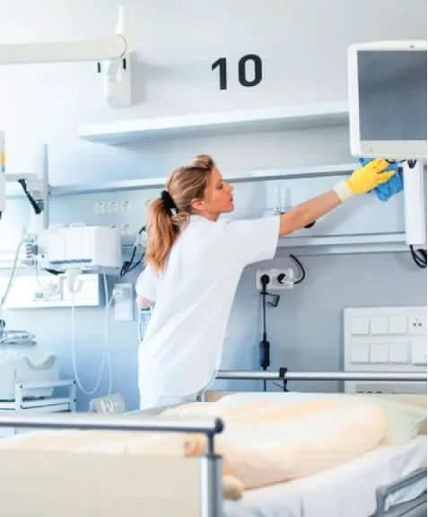 Eine Frau reinigt ein Krankenhauszimmer