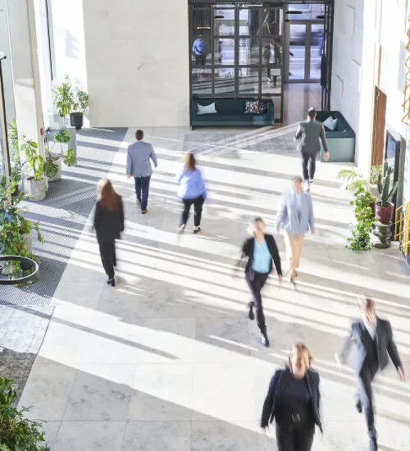 Eingangsbereich eines Gebäudes von innen mit Menschen die durchlaufen