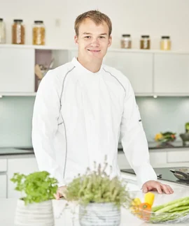 Ein lächelnder Koch steht in der Küche