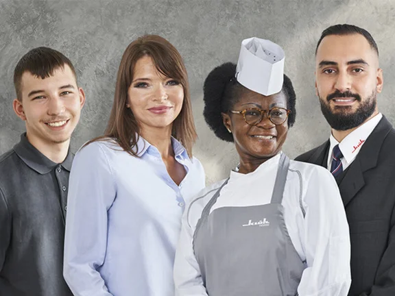 Ein Gruppenbild von vier Personen unterschiedlicher Berufen von dem Unternehmen Klüh