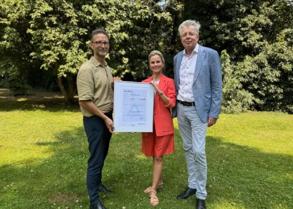 Gruppenbild von drei Personen mit dem ZNU-Standard Nachhaltiger Wirtschafter Zertifikat für Klüh Service Management GmbH