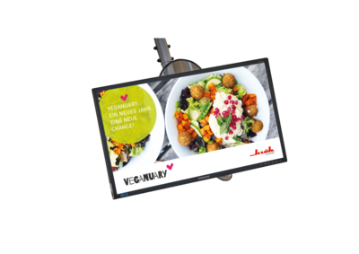 Ein Bild von einem Samsung Monitor auf dem ein Aktionsbild von Klüh Catering ist vom VEGANUARY mit einem Tellergericht