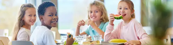 Ein Gruppe junger Schüler essen gemeinsam zu Mittag.