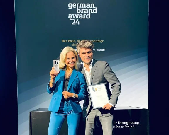 Ein Bild von einer Frau und einem Mann bei dem german brand award '24, beide halten jeweils ein Preis in der Hand und lächeln
