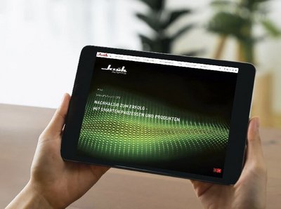 zwei Hände halten ein Tablet, auf dem Bildschirm ist Klüh Nachhaltigkeitsbericht 2022 zu sehen