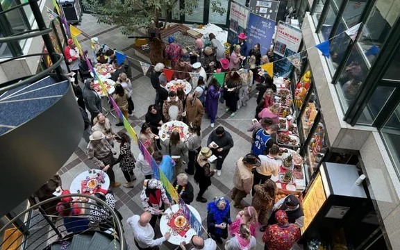 Karnevalsfeier im Atrium mit verkleideten Menschen aus der Vogelperspektive