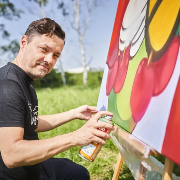 Künstler Damian Bautsch malt ein Gemälde mit einer Graffiti-Sprühdose