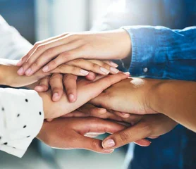 Ein Bild von viele Hände die aufeinander gestapelt sind und ein Turm bilden