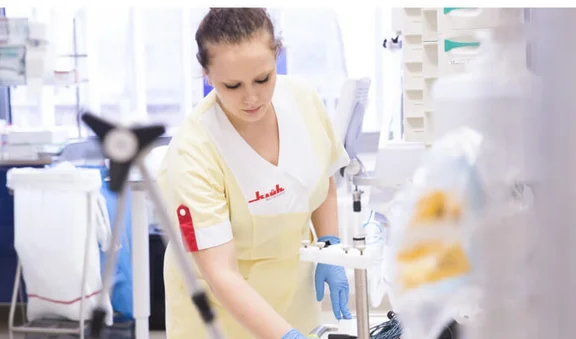 Klüh Reinigungskraft reinigt ein Krankenhauszimmer