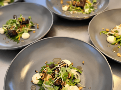 Ein Bild von einem Tisch mit vielen grauen Tellern mit dem selben Gericht