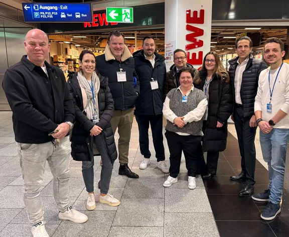 Ein Gruppenbild von neun lächelnden Menschen