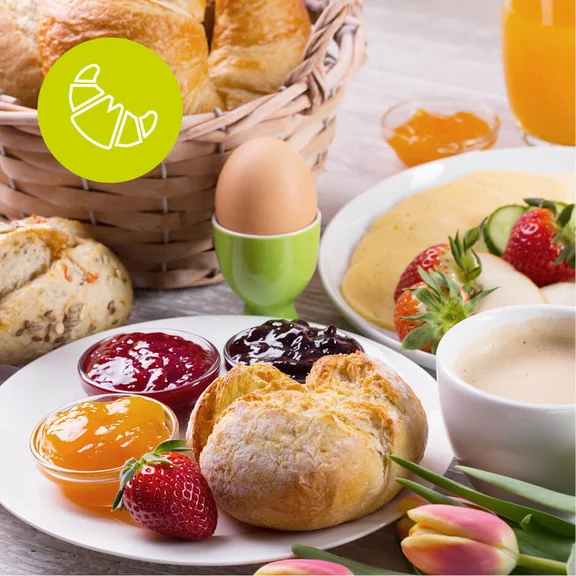 Frühstück mit Brötchen und verschiedenen Marmemeladenschalen, Ei, Kaffee und Croissant