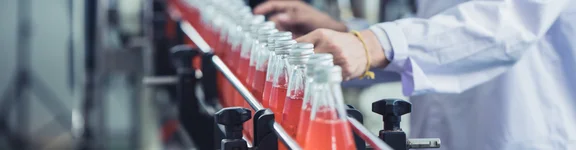 Auschnitt zeigt Fließbandarbeiter, die reihenweise Flaschen auf dem Laufband bearbeiten.