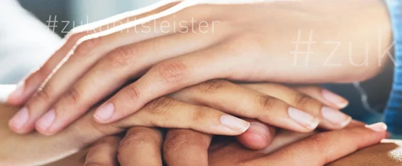 Ein Bild von vielen Händen die aufeinander liegen und ein Turm bilden, auf dem Bild ist oft der Schriftzug: #zukunftsleister