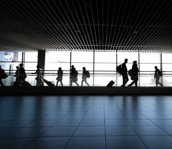 Ein Bild vom Flughafen Gate Bereich und viele herumlaufenden Menschen mit Gepäck und Koffern