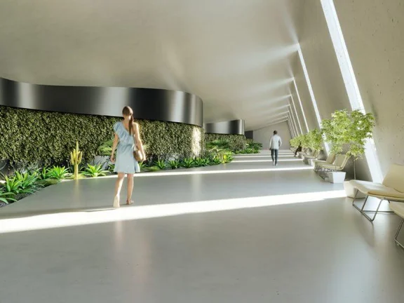 Ein Bild von einem modernem hellem Flur mit einer Mooswand, ein Mann und eine Frau laufen den Flur entlang