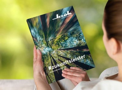 eine Frau hält den Nachhaltigkeitsbericht #zukunftsleister von Klüh in den händen und schaut drauf