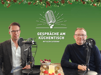 Catering Geschäftsführer Olschar (links) und Greth (rechts) sitzen an einem Tisch mit Mikrofonen