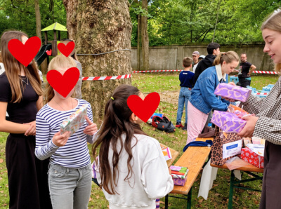 Ein Bild von Kindern die Geschenke überreicht bekommen von einer Frau
