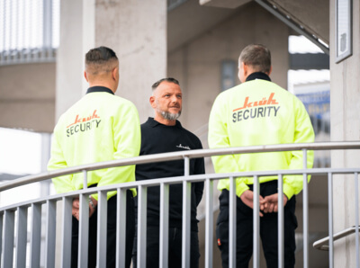 Drei Männer im Berufskleidung von Klüh Security