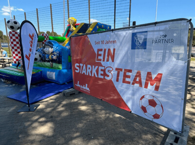 Ein Bild von einer Kinder Hüpfburg neben einem Partnerbanner von Klüh Multiservices und VFL Bochum 